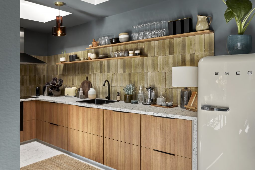 Kuchyně kombinuje dřevo, zelené keramické retro obklady a kamennou desku